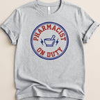 Gray t-shirt with "Pharmacist On Duty" in a blue circle and lightning bolt graphic.