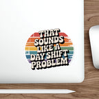 Sticker with retro-style text "That Sounds Like a Day Shift Problem" on a laptop.