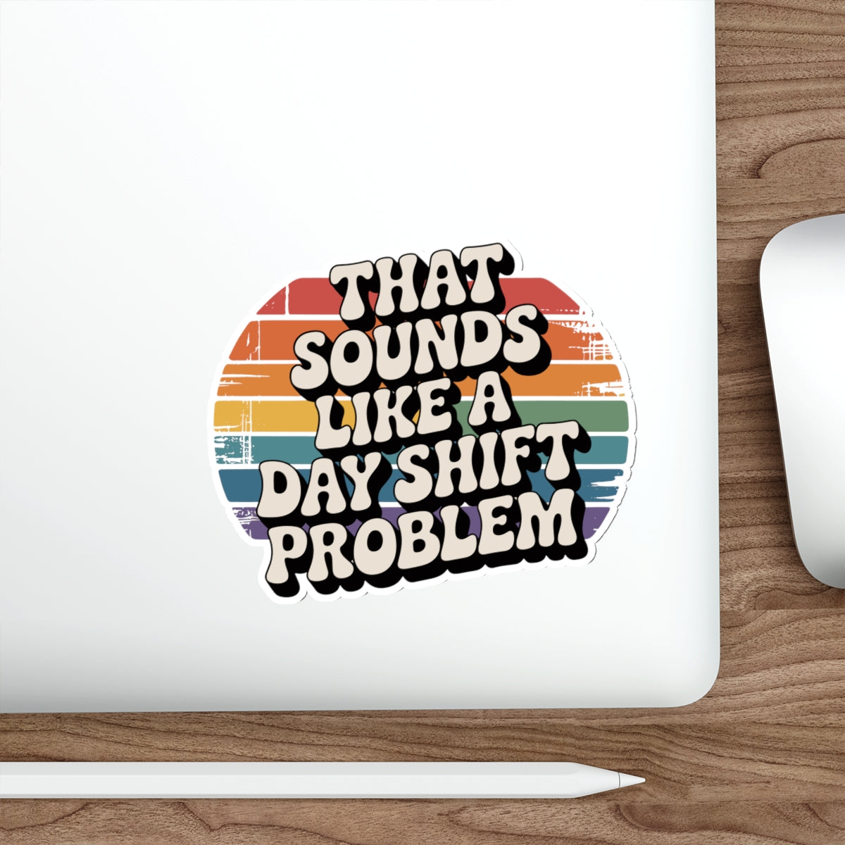 Sticker with retro-style text "That Sounds Like a Day Shift Problem" on a laptop.