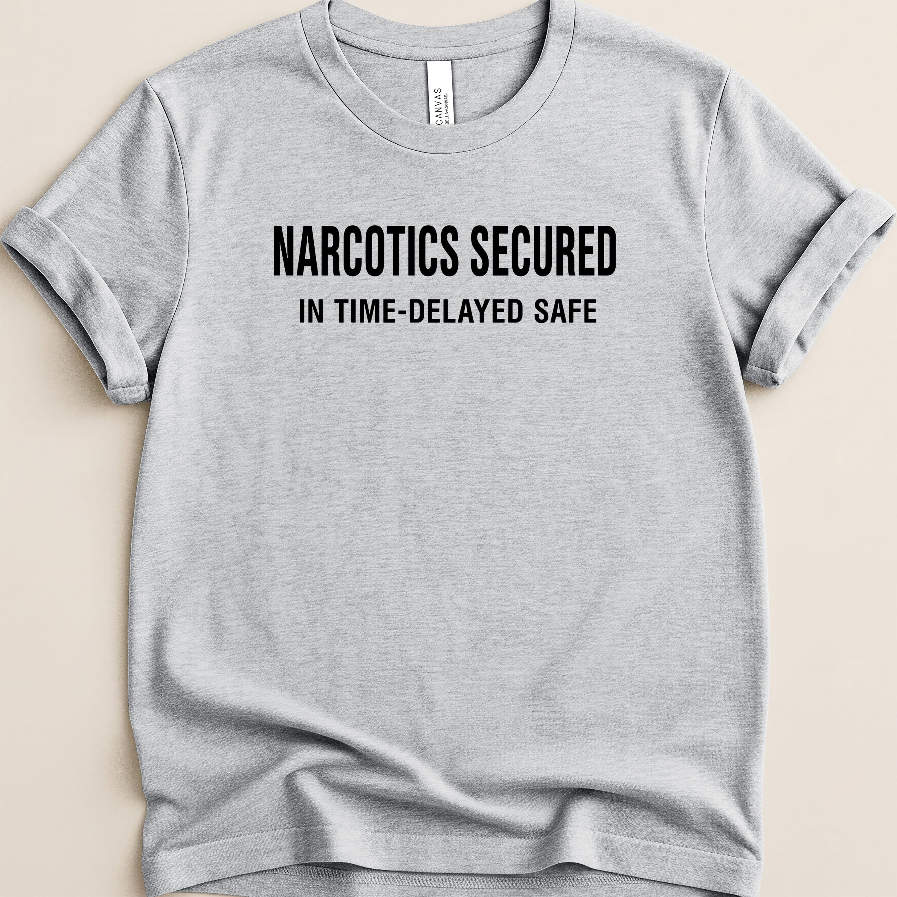 Gray t-shirt with black text "NARCOTICS SECURED IN TIME-DELAYED SAFE".