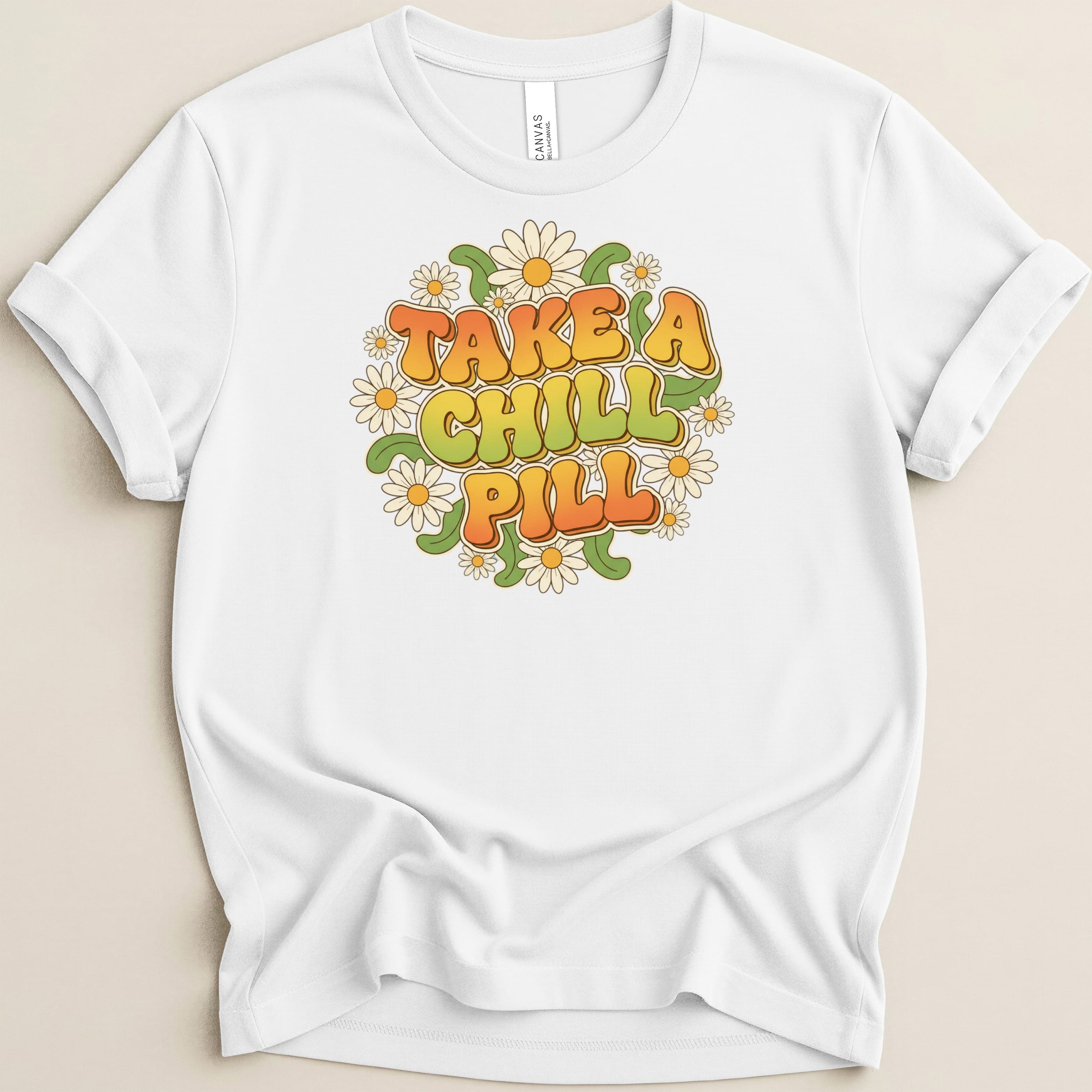 White t-shirt with "TAKE A CHILL PILL" text surrounded by daisies.