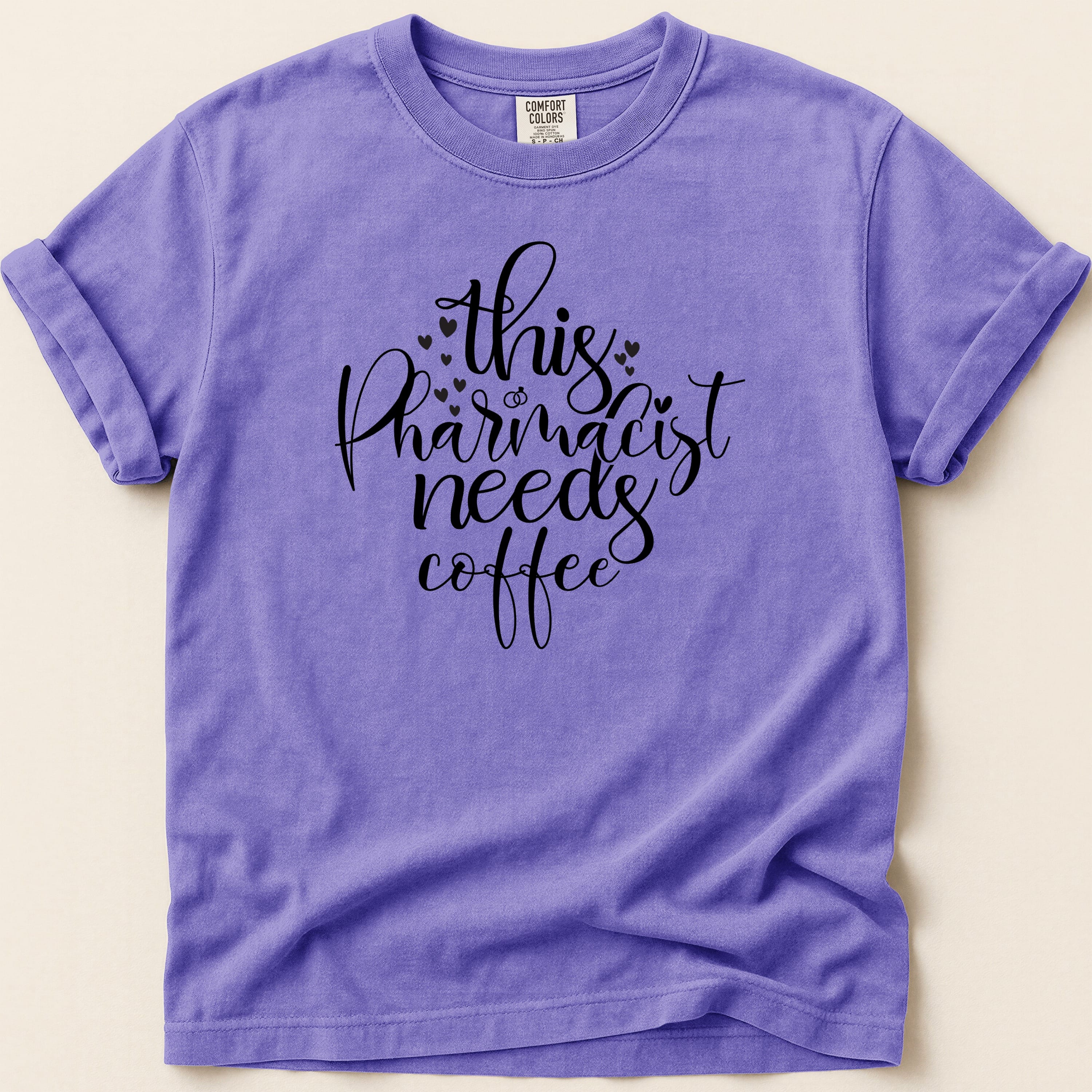 Purple t-shirt with "This Pharmacist Needs Coffee" text design.