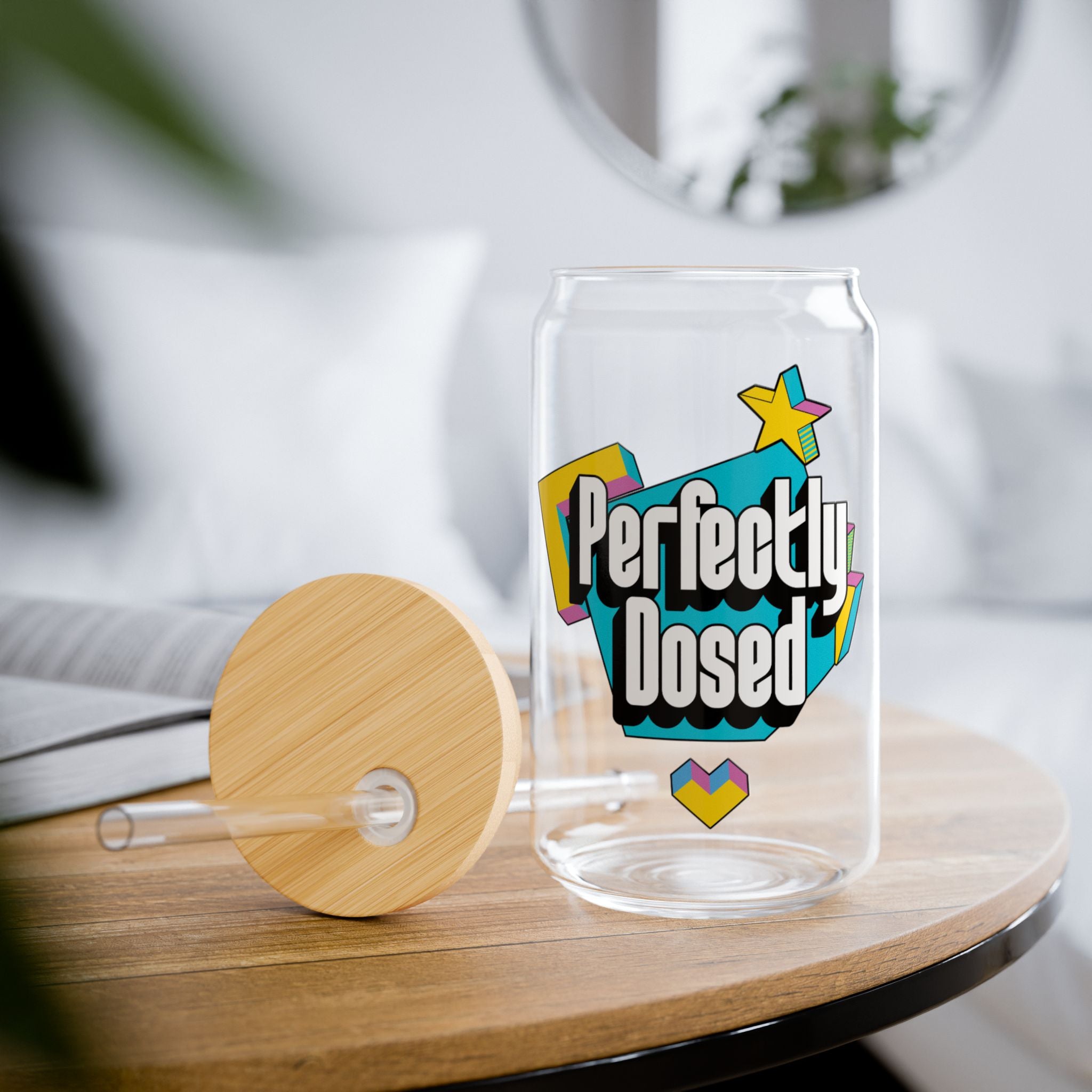 Clear glass can-shaped tumbler with bamboo lid and straw, "Perfectly Dosed" text.
