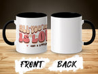 White mug with "All you need is love and a little..." text, black interior and handle.
