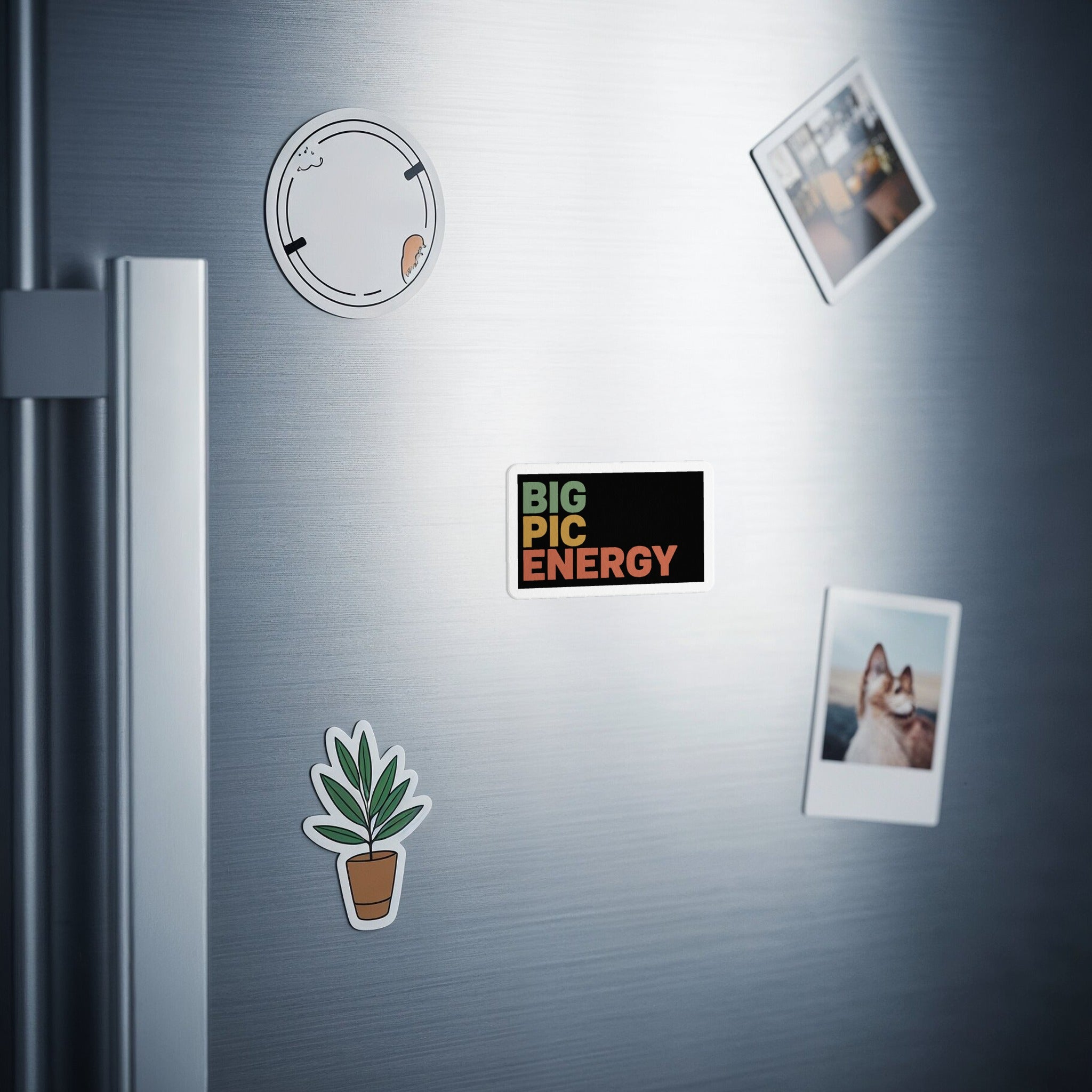 Rectangular magnet with "BIG PIC ENERGY" text on a refrigerator.