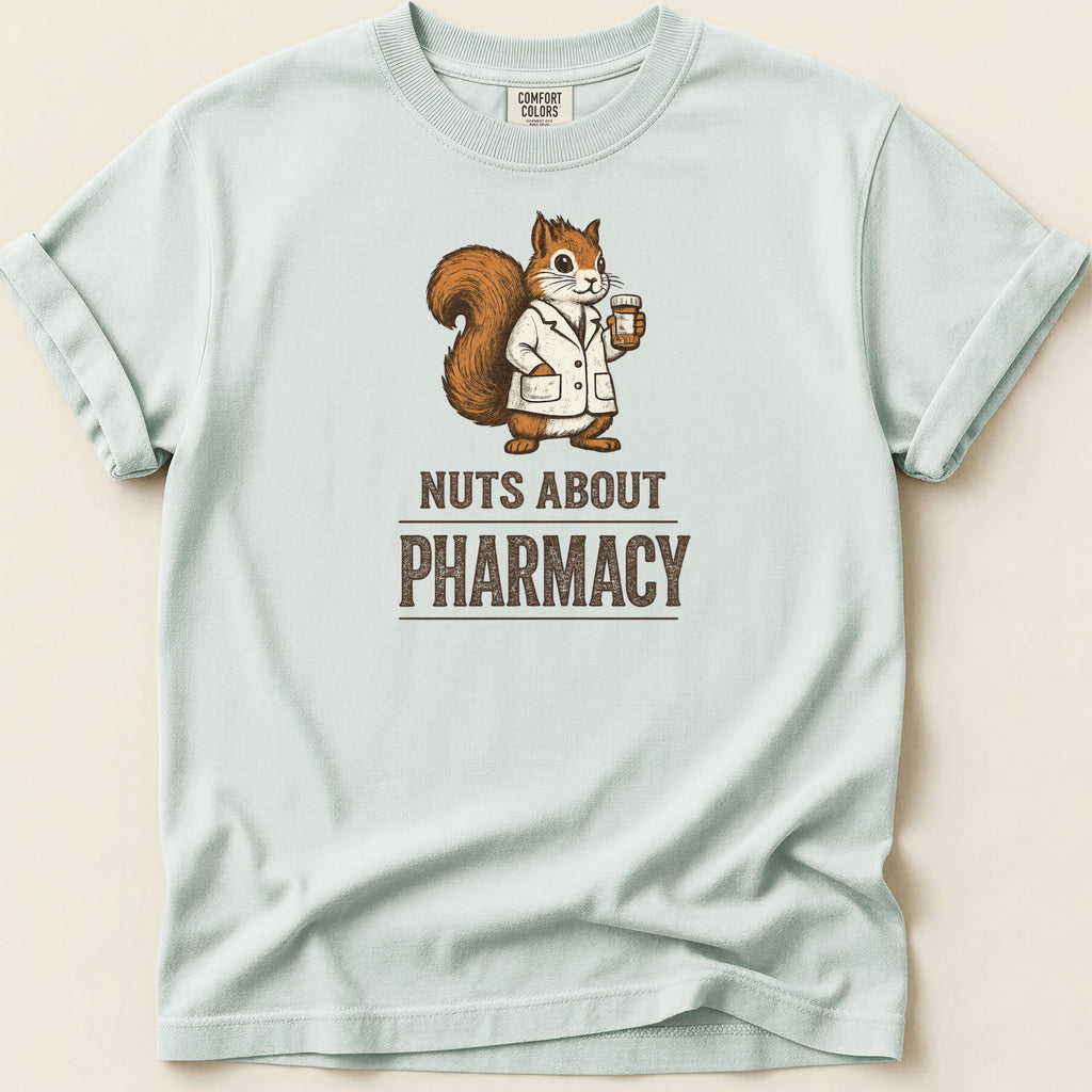 Pale blue t-shirt with a squirrel in a lab coat holding a pill bottle, text reads "NUTS ABOUT PHARMACY".