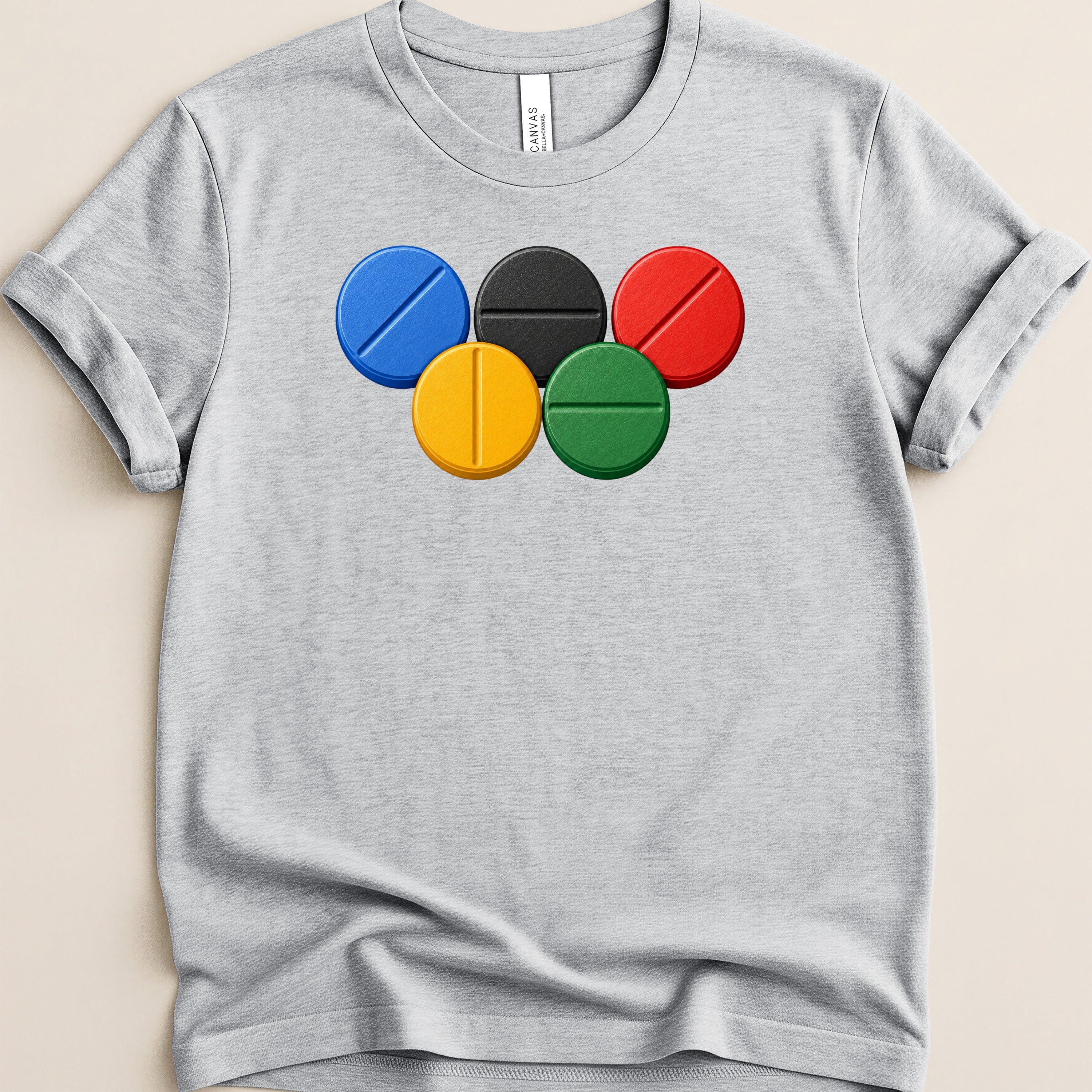 Grey t-shirt with a print of five Olympic rings depicted as pills.