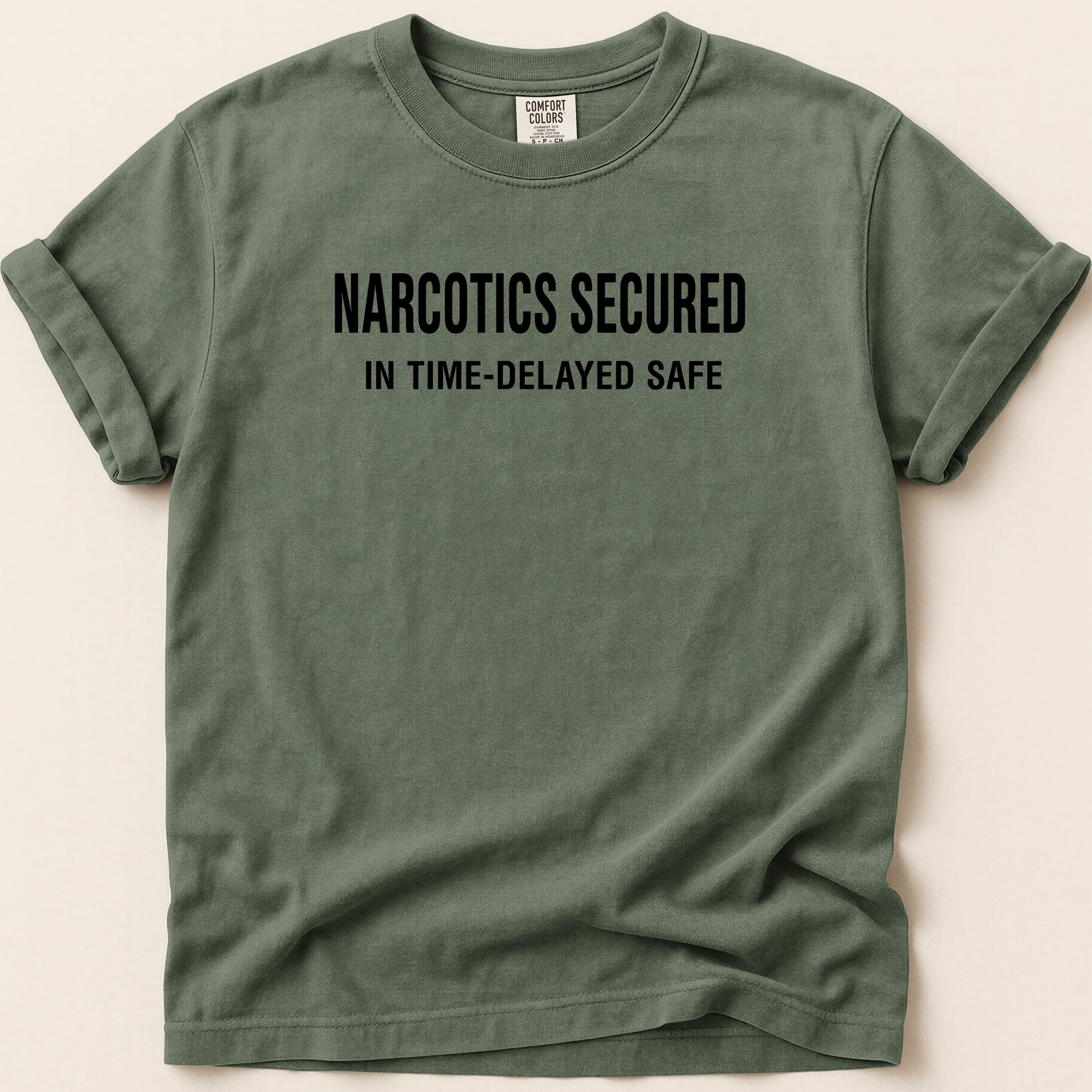 Green t-shirt with "NARCOTICS SECURED IN TIME-DELAYED SAFE" text.