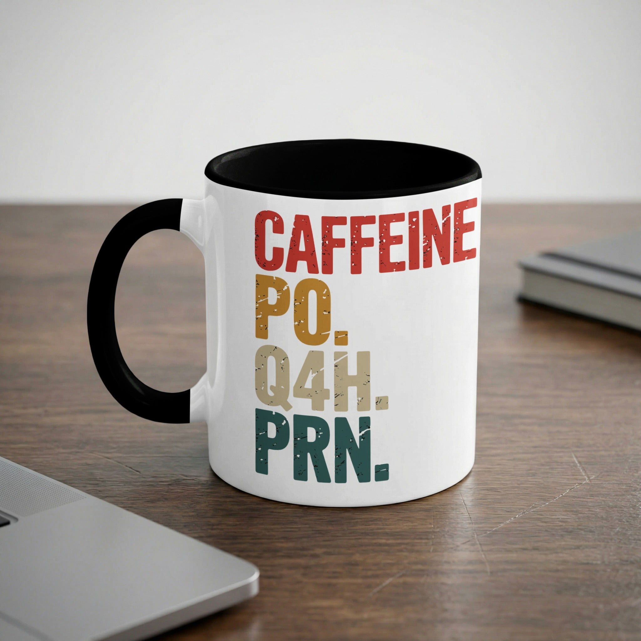 White mug with black rim and handle, features text "CAFFEINE PO. Q4H. PRN."