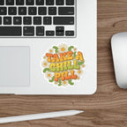 Retro sticker with "TAKE A CHILL PILL" text and daisies on a laptop.