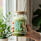 Glass tumbler with "LACY" text, straw, and green drink.