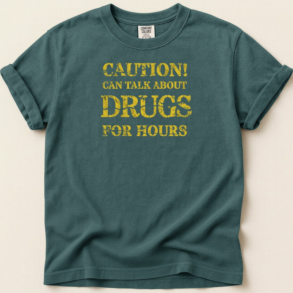 Teal t-shirt with yellow distressed lettering that reads "CAUTION! CAN TALK ABOUT DRUGS FOR HOURS".