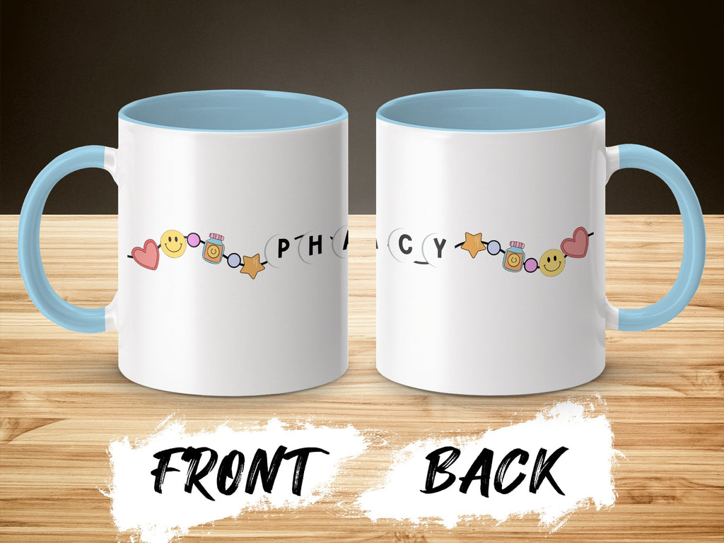 White mug with light blue handle and rim, featuring cartoon pills and smiley faces.