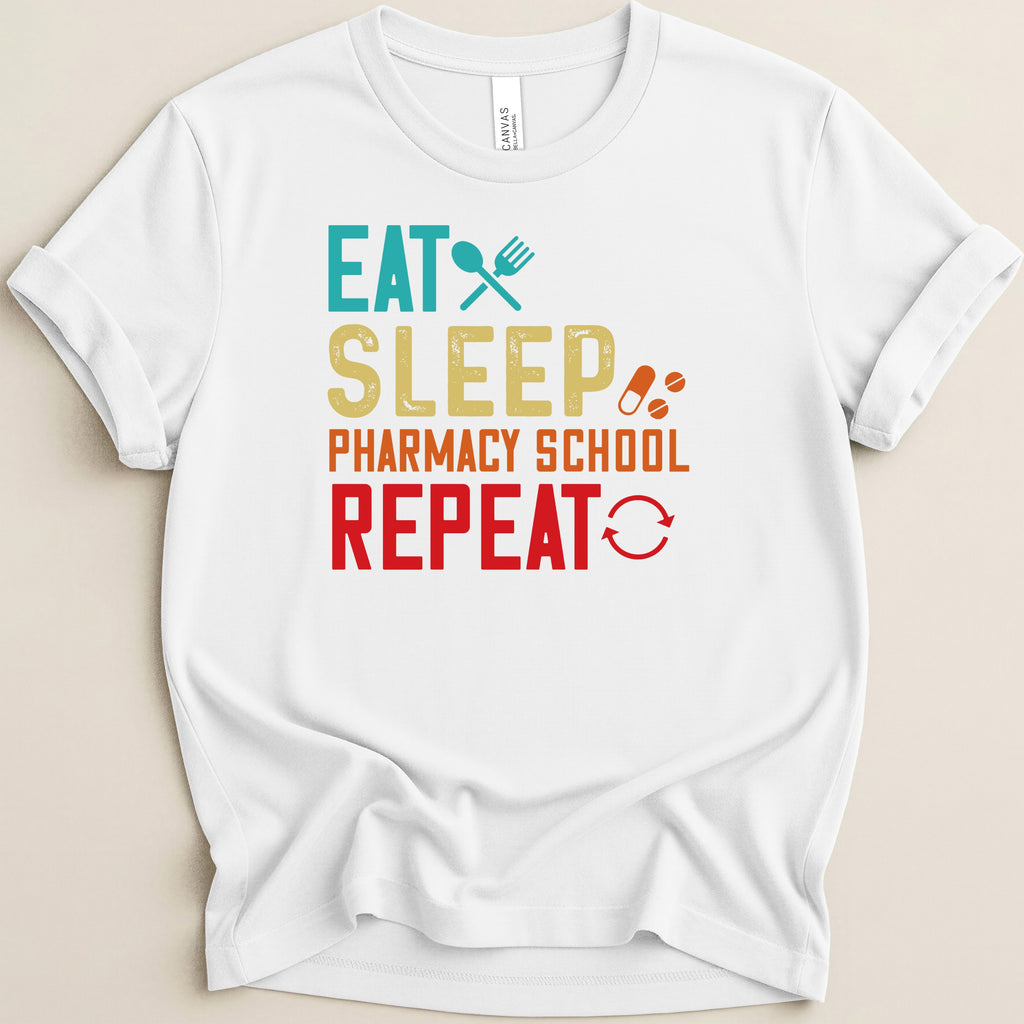 White t-shirt with "Eat Sleep Pharmacy School Repeat" text and icons.