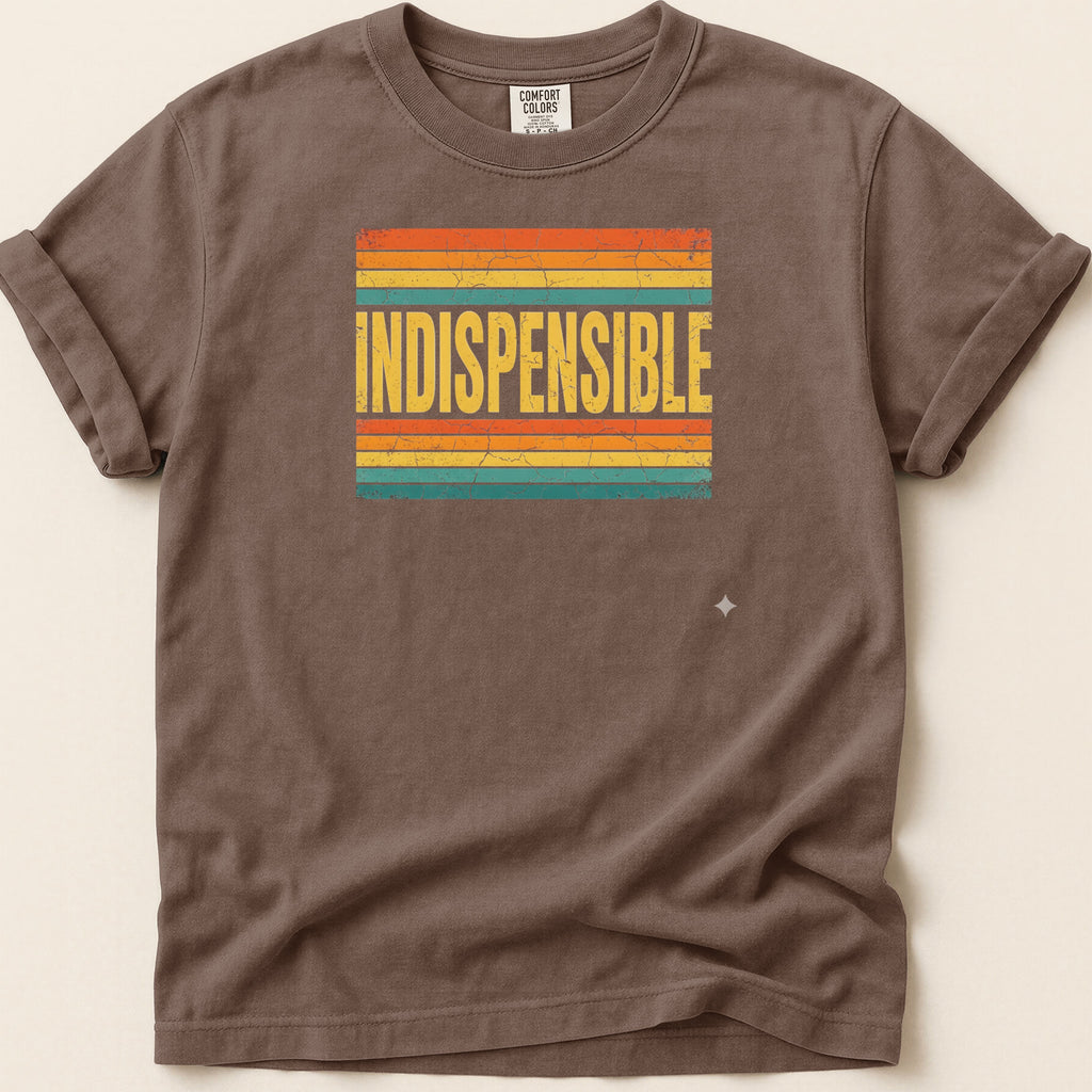Brown t-shirt with "INDISPENSABLE" in yellow over distressed horizontal stripes.