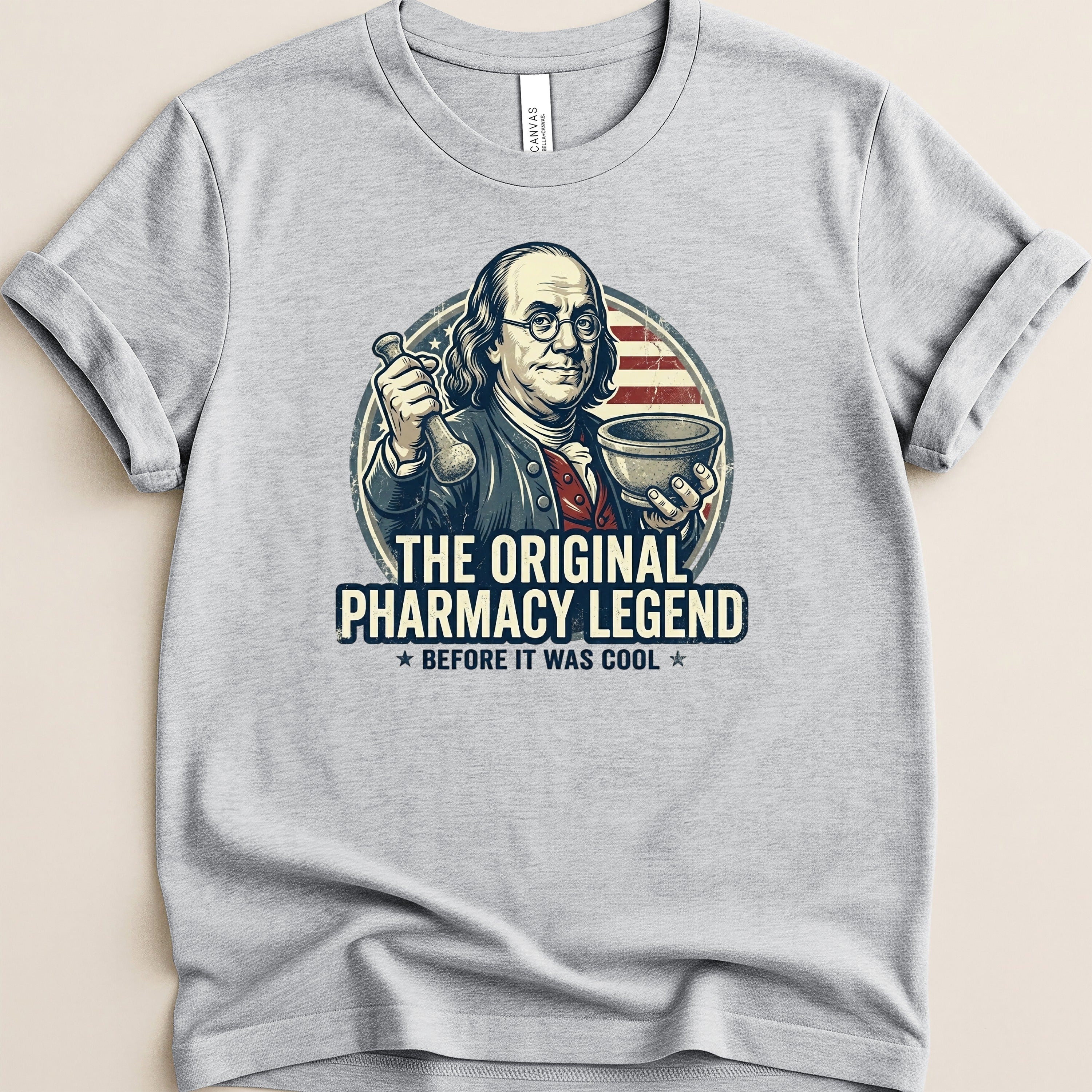 T-shirt graphic: Benjamin Franklin holding pharmacy tools, "The Original Pharmacy Legend".