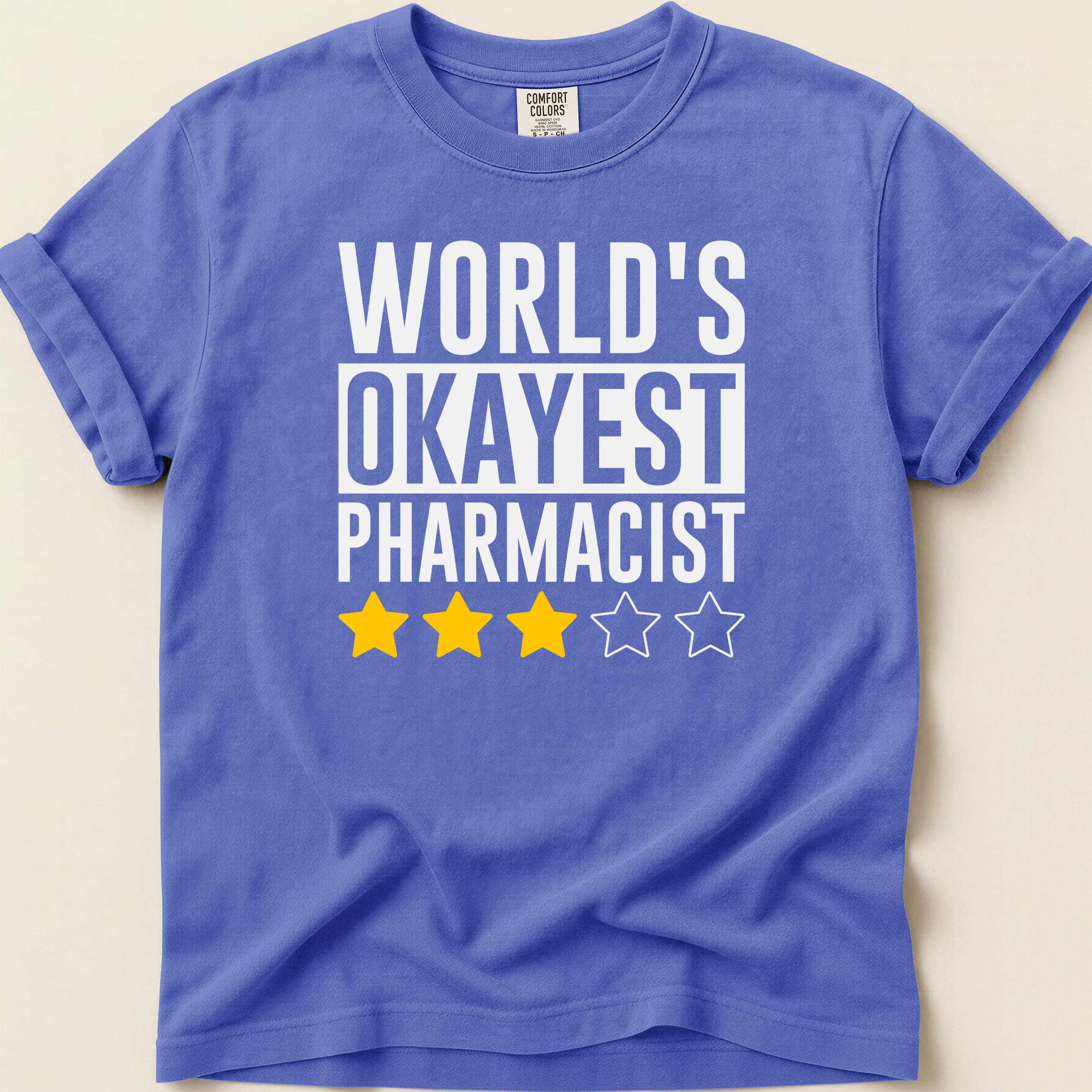 Purple t-shirt with "World's Okayest Pharmacist" and three yellow stars.