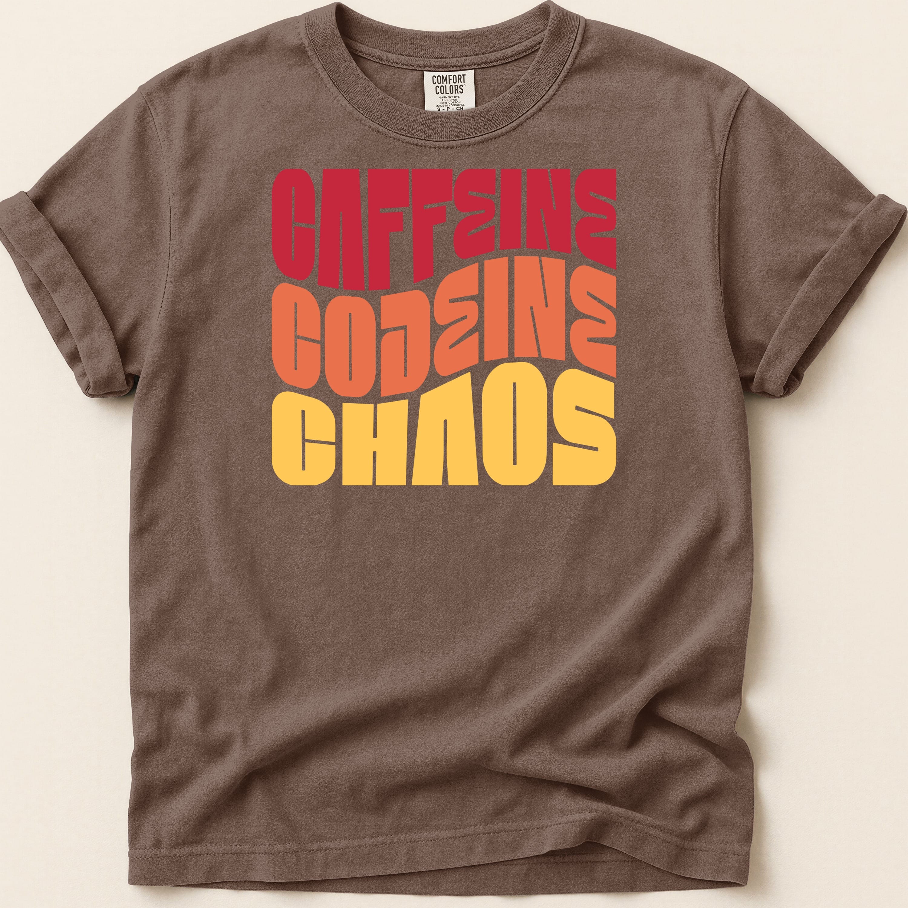Brown t-shirt with "CAFFEINE CODEINE CHAOS" text in stacked, retro-style lettering.