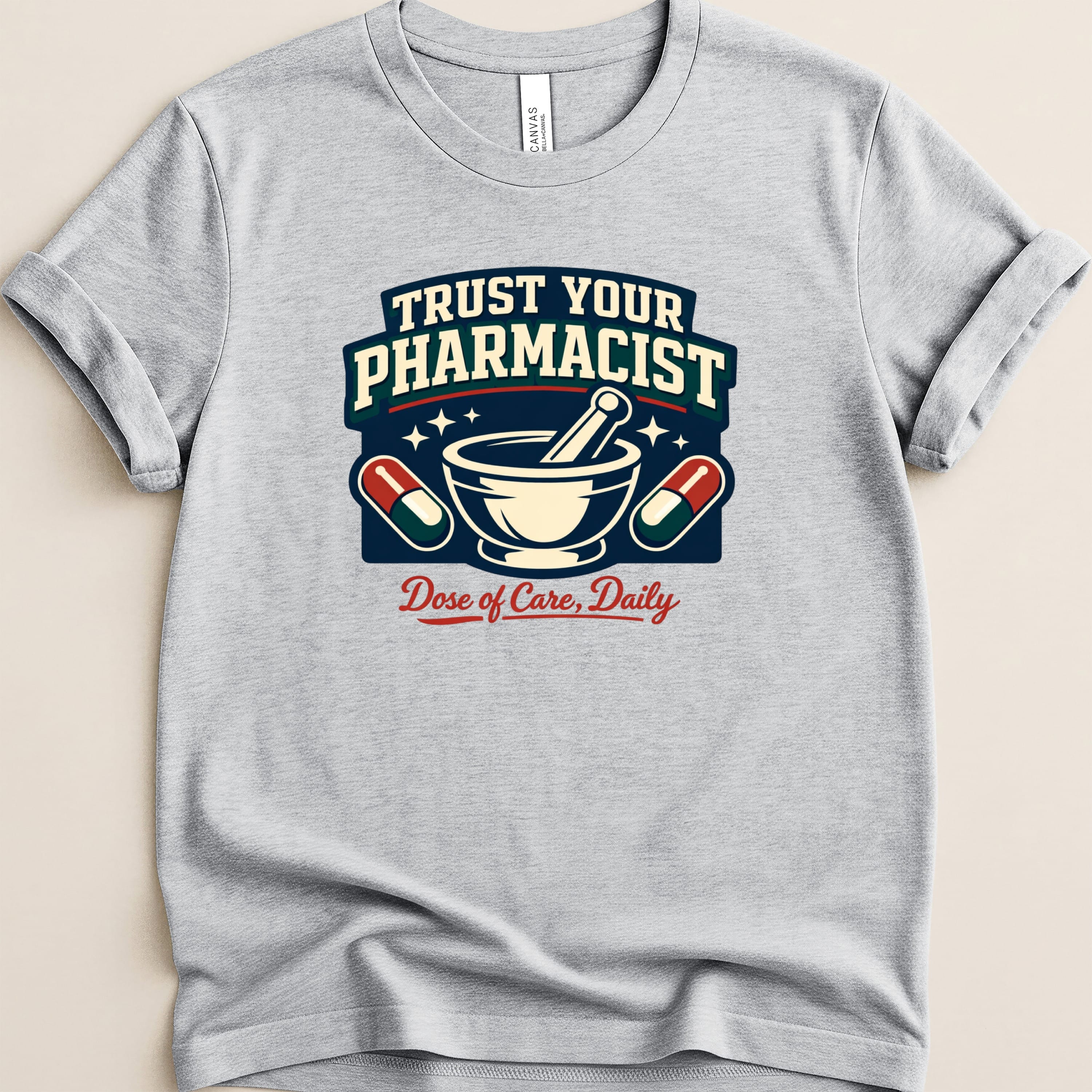 Gray t-shirt with "Trust Your Pharmacist" and "Dose of Care, Daily" text and graphics.