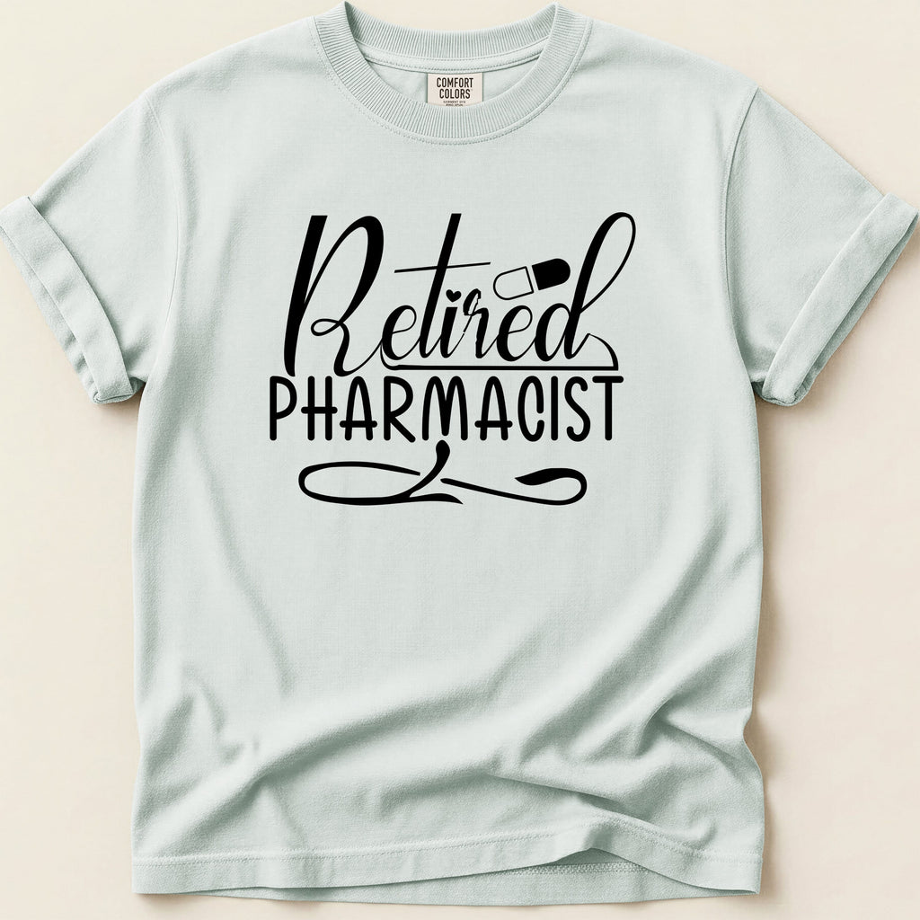 Retired Pharmacist text with pill on a light blue t-shirt.