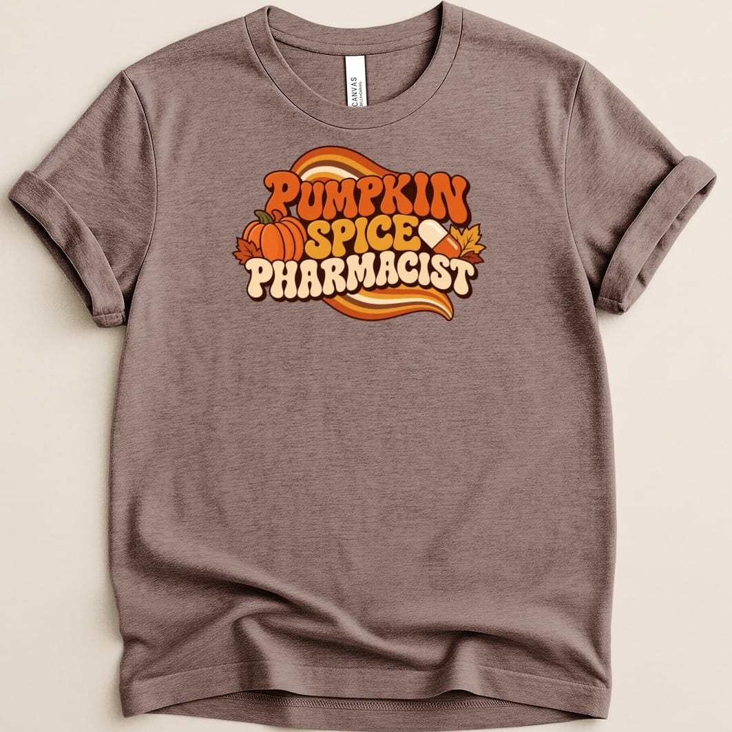 Brown short-sleeve t-shirt featuring a retro graphic with the text PUMPKIN SPICE PHARMACIST, a pumpkin, and a capsule.