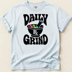 Light blue t-shirt with black text "DAILY RX GRIND" and mortar with colorful pills.