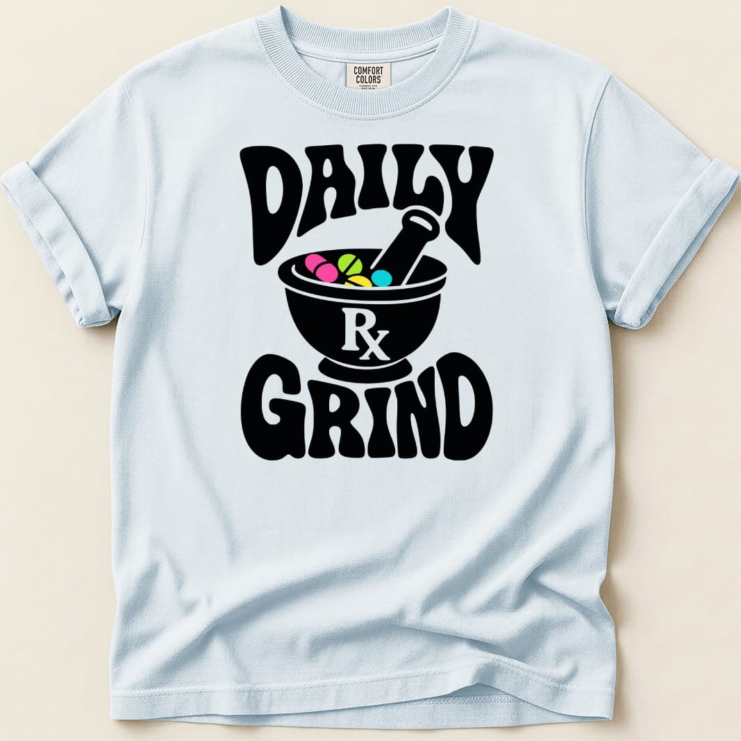 Light blue t-shirt with black text "DAILY RX GRIND" and mortar with colorful pills.