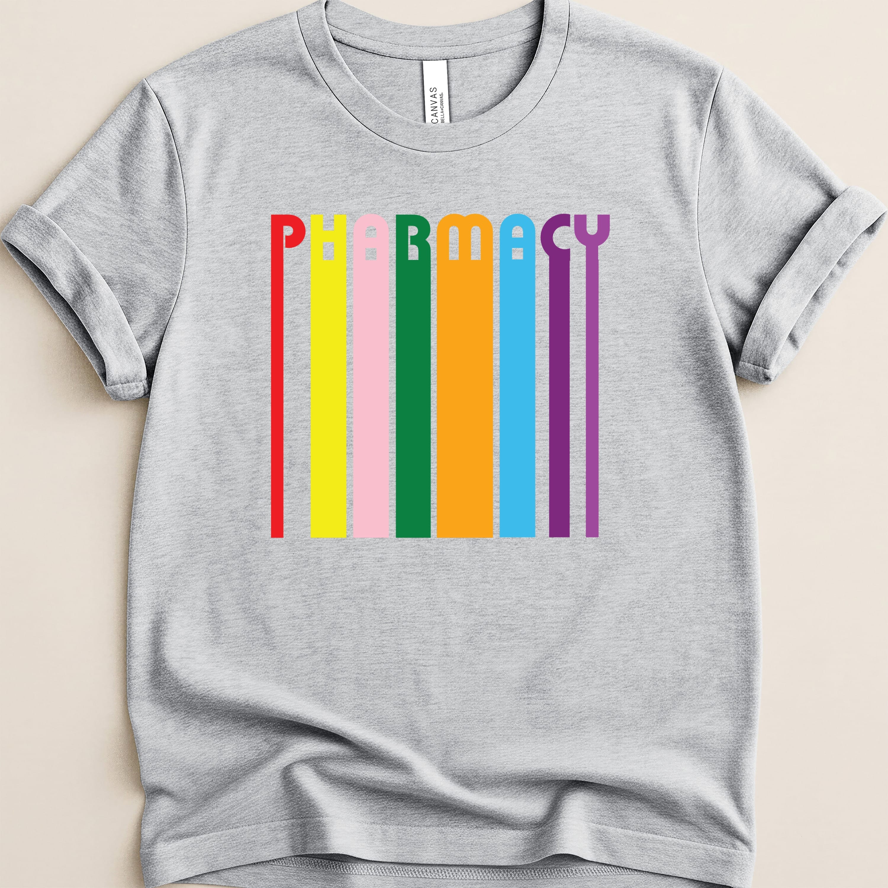 Grey t-shirt with colorful vertical stripes spelling out PHARMACY.